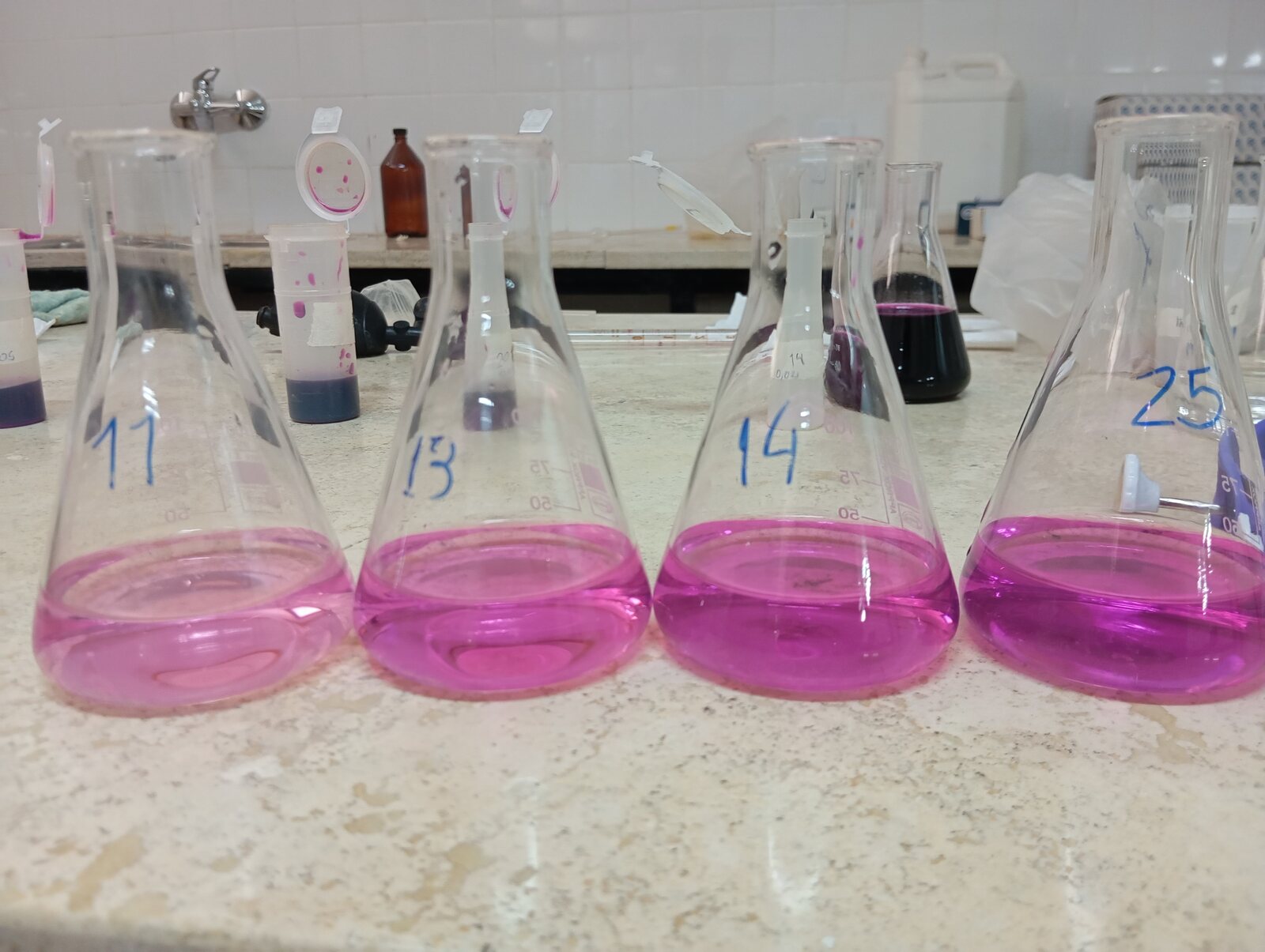 Erlenmeyer con soluciones rosadas durante la calibración del método de carbono activo POXC